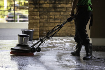 A worker cleaning the floor with polishing machine