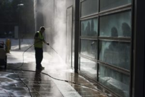 A power washing professional tending to the outside of a business